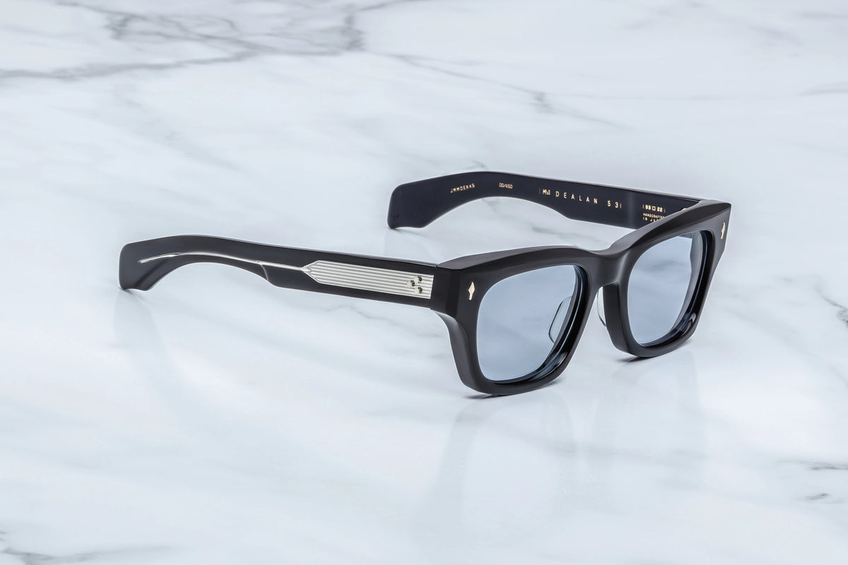  Side profile view of the Jacques Marie Mage Dealan 53 Obscure sunglasses. The substantial, custom double-laminated ink-blue acetate temple arms extend straight back for 147mm, showing off a flawless, hand-polished glossy finish that catches the light through the translucent blue framing