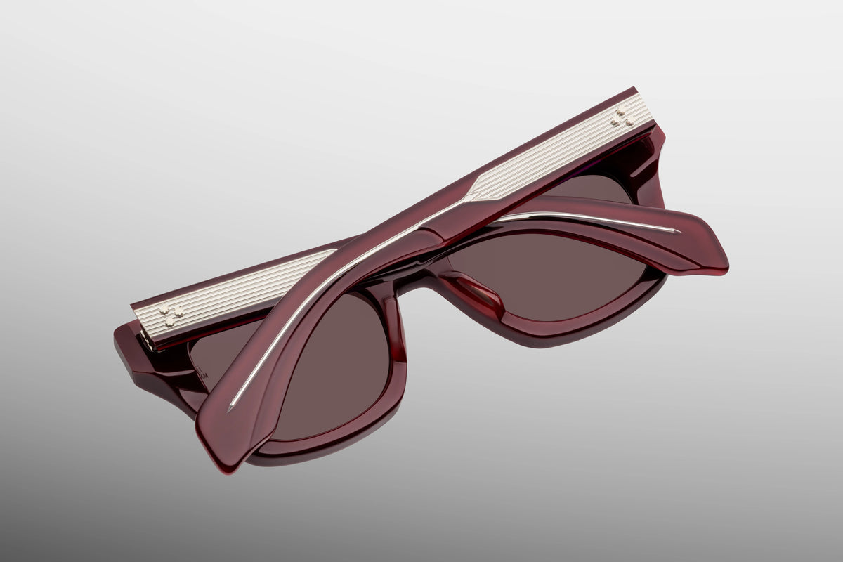  Close-up interior detail shot of the Jacques Marie Mage Dealan Bordeaux Empire frame architecture. The inner view showcases the deep red-burgundy rims against the exposed metallic hardware. Gold foil-stamped text on the inner temple arm indicates the individual limited-edition serial number out of the exclusive global batch alongside the "Handcrafted in Japan" production text. Available at WINK Optometrists.