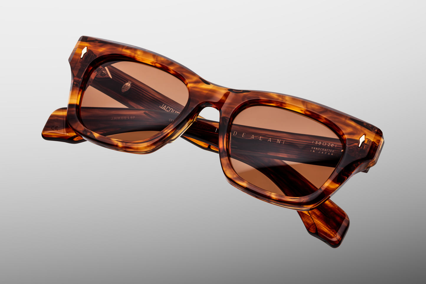 Close up front detail of Jacques Marie Mage Dealan sunglasses in Bourbon showing signature arrowhead rivets, sculpted acetate frame and tinted lenses – available at Wink Optometrists