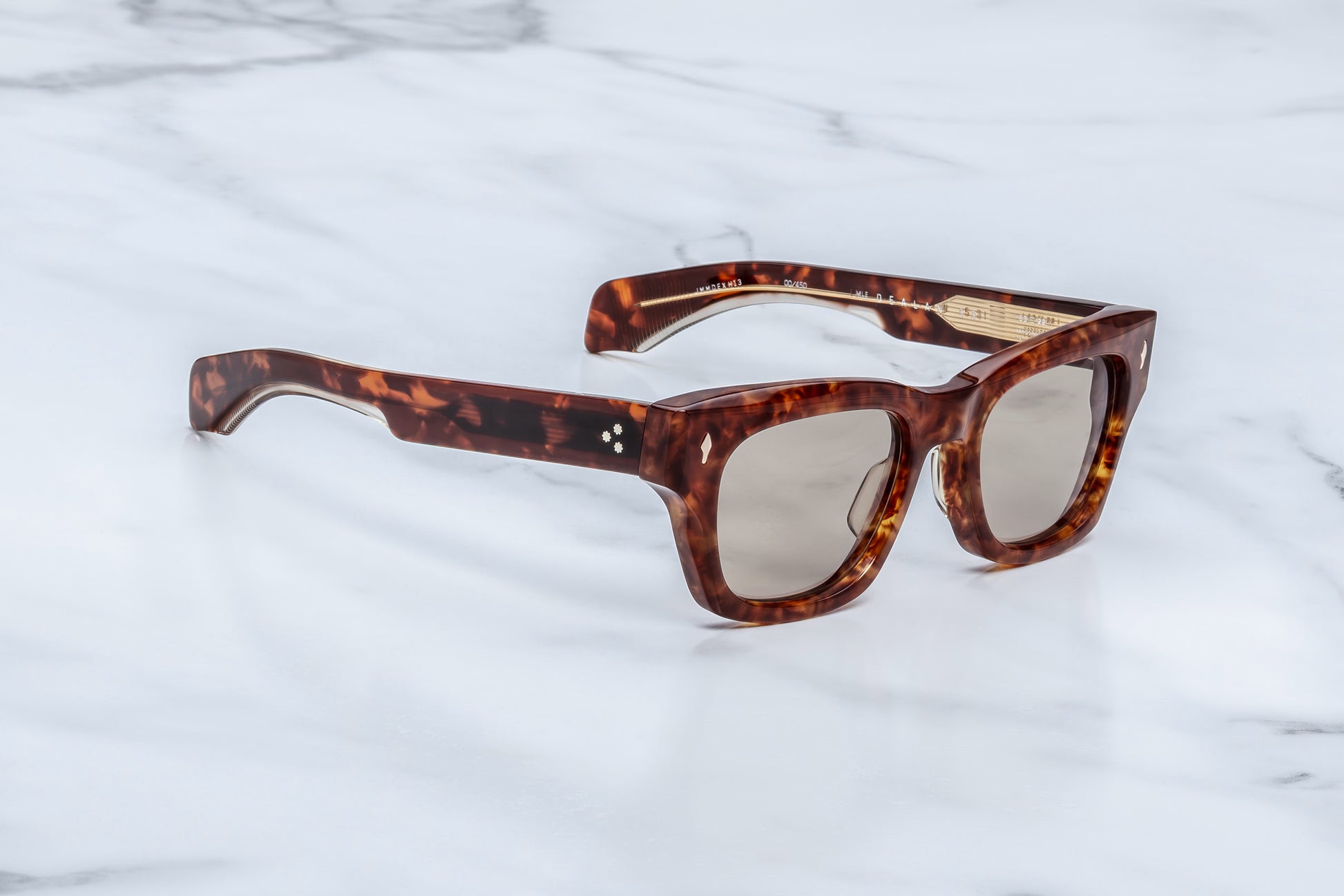 Three-quarter angle of Jacques Marie Mage Dealan 53 Honeycomb sunglasses, showing the thick sculptural acetate beveling and the transition from the rich tortoiseshell frame to the wide, double-laminated temples