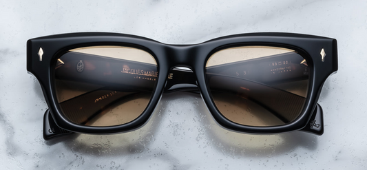 Front view of Jacques Marie Mage Dealan 53 Noir 15 sunglasses, featuring a refined, rectangular frame in a sleek black acetate finish. The frame offers a sophisticated, minimalist design with subtle curves at the edges. The dark lenses contrast with the clean lines of the frame, delivering a timeless, high-end look