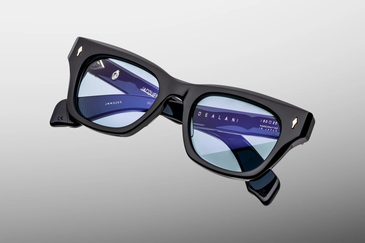 Top-down view of the Jacques Marie Mage Dealan Obscure sunglasses, emphasizing the substantial 10mm gauge thickness of the front frame block. From above, the smooth alignment of the bold paddle temples is visible, showcasing the internal silver wire cores and the robust, dark gold 7-barrel hinges. Available at WINK Optometrists.