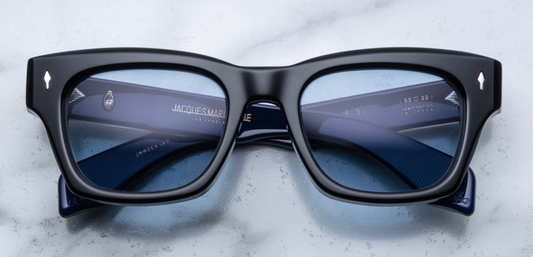 A bold, square Jacques Marie Mage Dealan frame in the "Sienne" colorway—crafted from 10 mm black cured cellulose acetate,exposed sterling‑silver wire‑core temple detailing and double‑laminated acetate construction. The front showcases JMM’s signature arrowhead metal inlays at the hinges. This medium-sized, ‘60s-inspired unisex frame is handcrafted in Japan in a limited batch, echoing mid‑1960s rock‑’n’-roll