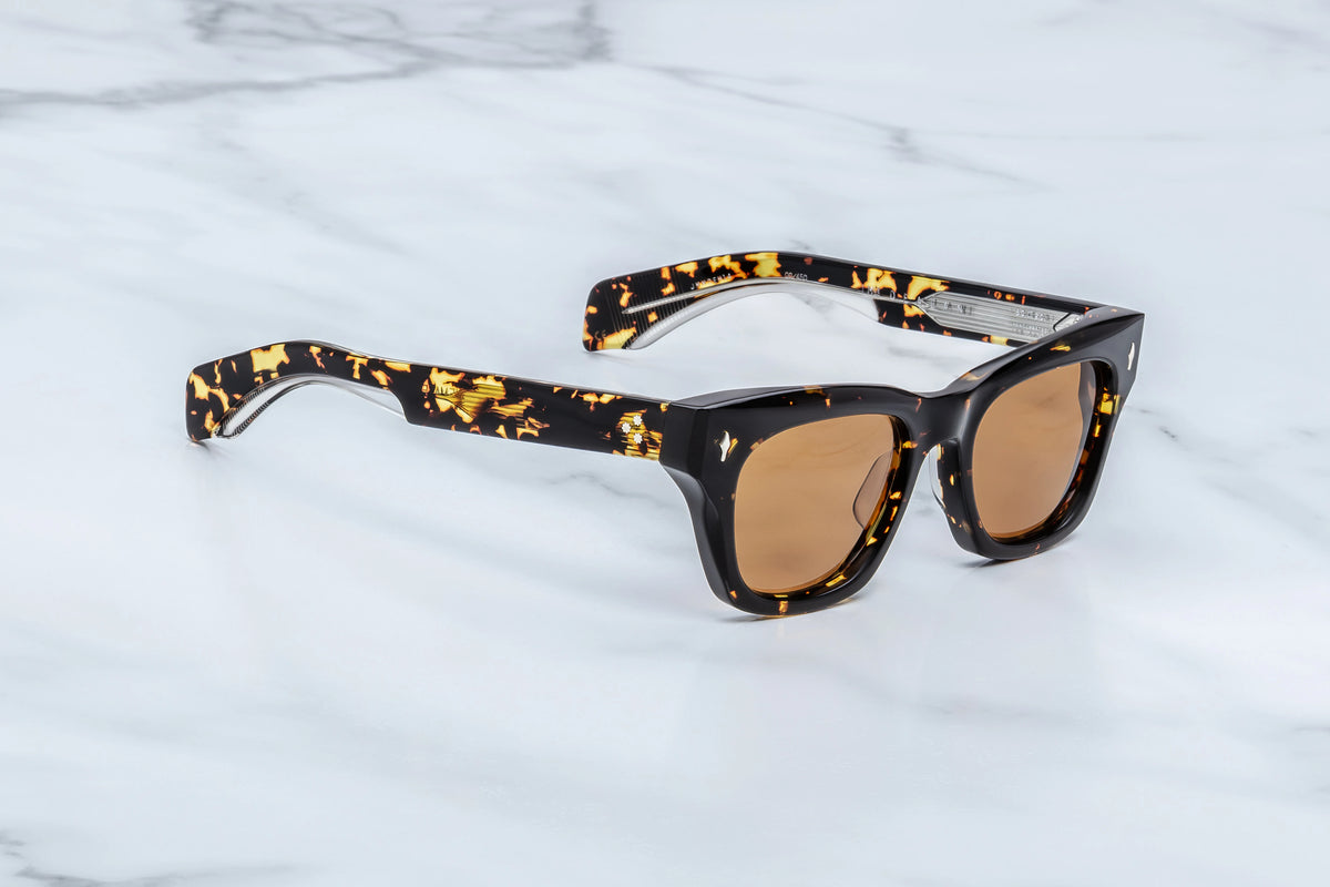 Side profile view of the Jacques Marie Mage Dealan Tokyo sunglasses. The thick, 142mm double-laminated tortoiseshell acetate temple arms run straight back, showing a glossy, highly polished finish that accentuates the deep brown and black mottled spots of the classic Tokyo patterning