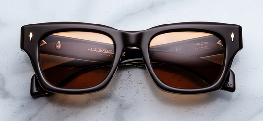 Front view of Jacques Marie Mage Dealan 53 sunglasses in Walnut, featuring a bold brown 10mm acetate frame, vibrant orange lenses, and dark gold signature arrowhead front pins.