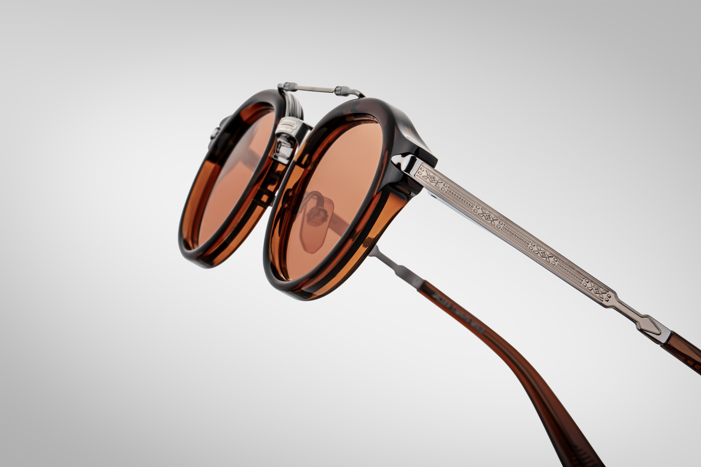 Side profile of Jacques Marie Mage Delage Zoltar highlighting brown acetate temple, fine Art‑Deco engraving, custom arrowhead monoblock hinge in light gold, and exposed sterling‑silver beta‑titanium structure.”