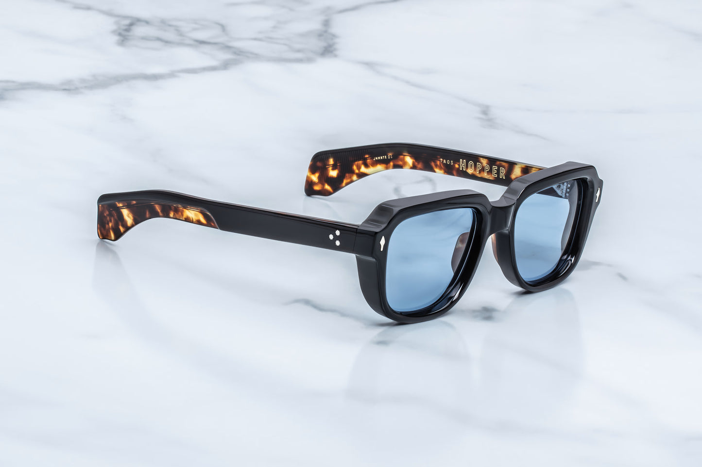 Three-quarter studio shot of the JMM Taos 10Y Noir, highlighting the substantial 12mm thick sculpted block frame and the fluid transition into the dual-laminated temples