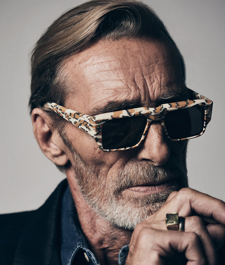 Portrait of a model wearing Jacques Marie Mage Devoto (Cheetah) sunglasses at WINK Optometrists, Melbourne — bold cheetah‑print acetate rectangular frame with grey lenses and strong brow‑line