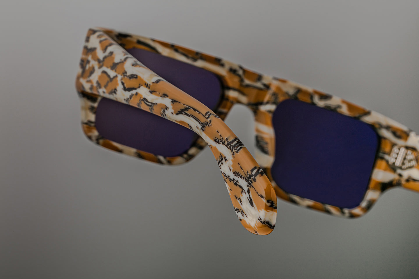 Back view of Jacques Marie Mage Devoto Cheetah sunglasses at WINK Optometrists Melbourne — inside of temple showing model serial number, cheetah print interior and hinge mechanism.