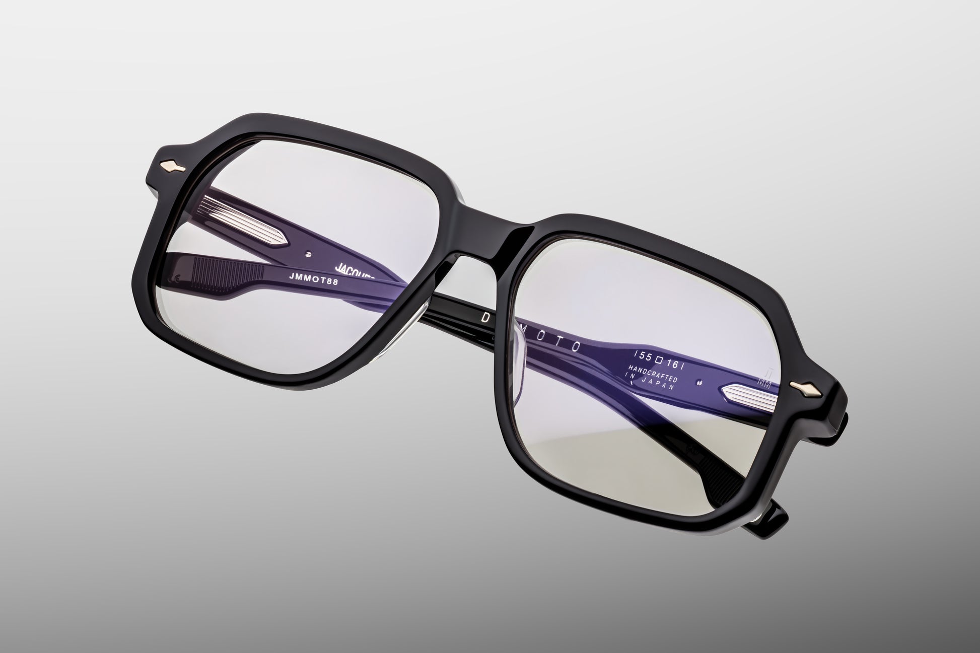 Close-up front detail of Jacques Marie Mage Domoto black frame highlighting arrowhead rivets and polished acetate finish