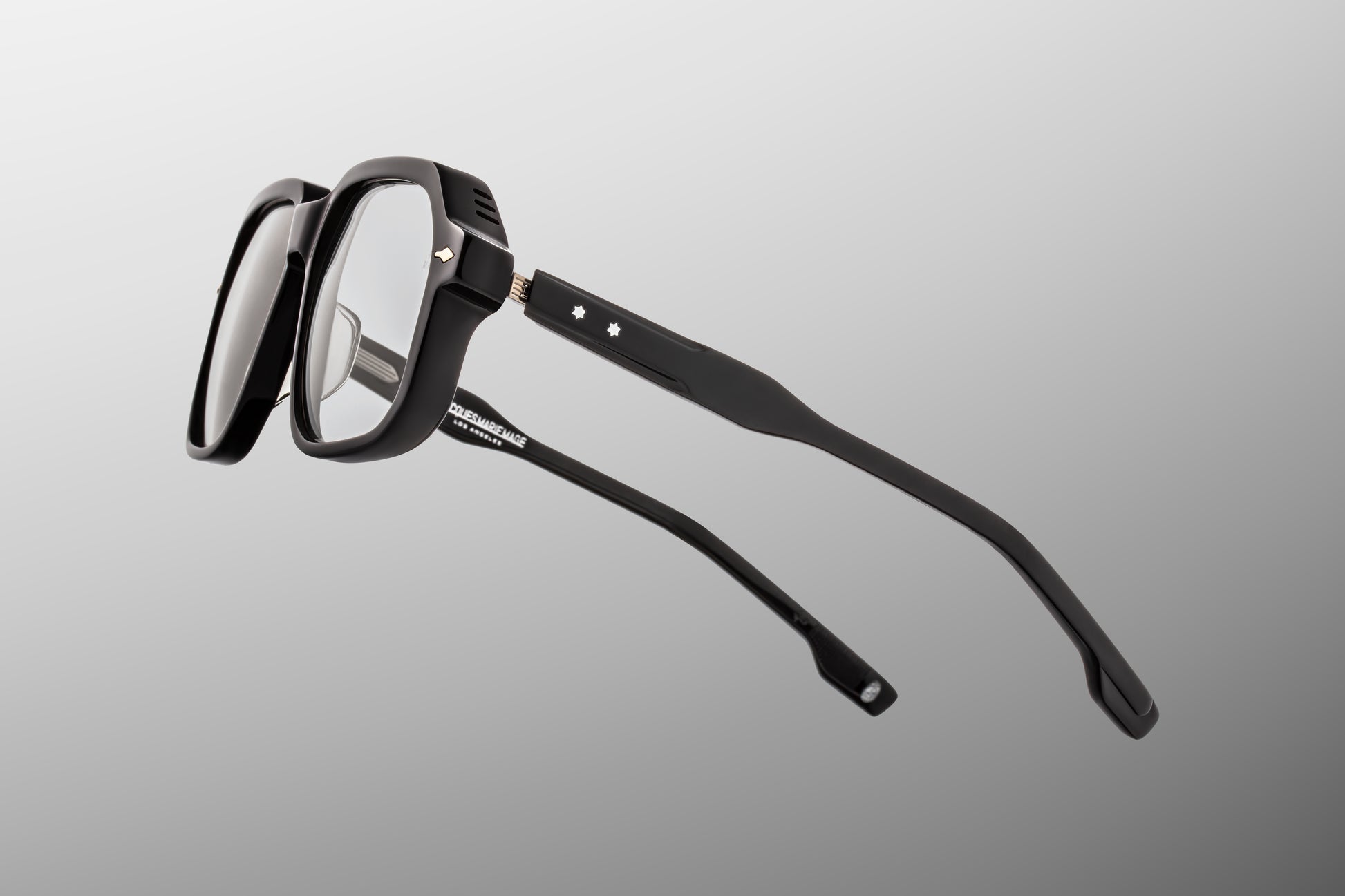 Close-up side detail of Jacques Marie Mage Domoto black frame showing engraved metal core and hinge construction