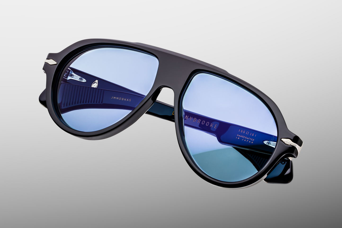 Top view of Jacques Marie Mage Donnybrooke Obscure sunglasses showing the strong sculptural brow line and wide pilot frame – available at WINK Optometrists. Close-up detail of Jacques Marie Mage Donnybrooke Obscure sunglasses lenses with premium aviator frame and anti-reflective coating