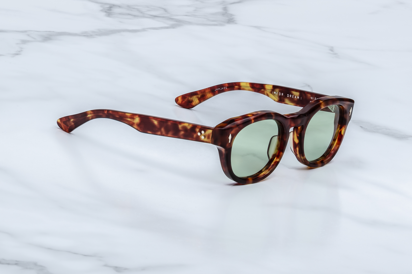 Profile of JMM Dr. Dream Baltic — translucent Baltic acetate temple with exposed silver wire-core and a refined 7-barrel hinge, nodding to the legacy of John & Yoko