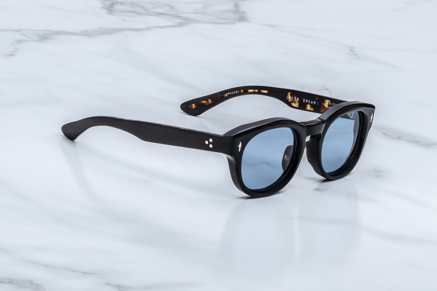 Side profile of the Dr. Dream Noir — sleek black double-laminated temples revealing semi-exposed wire-core and custom silver 7-barrel hinge, honoring the John & Yoko by JMM legacy