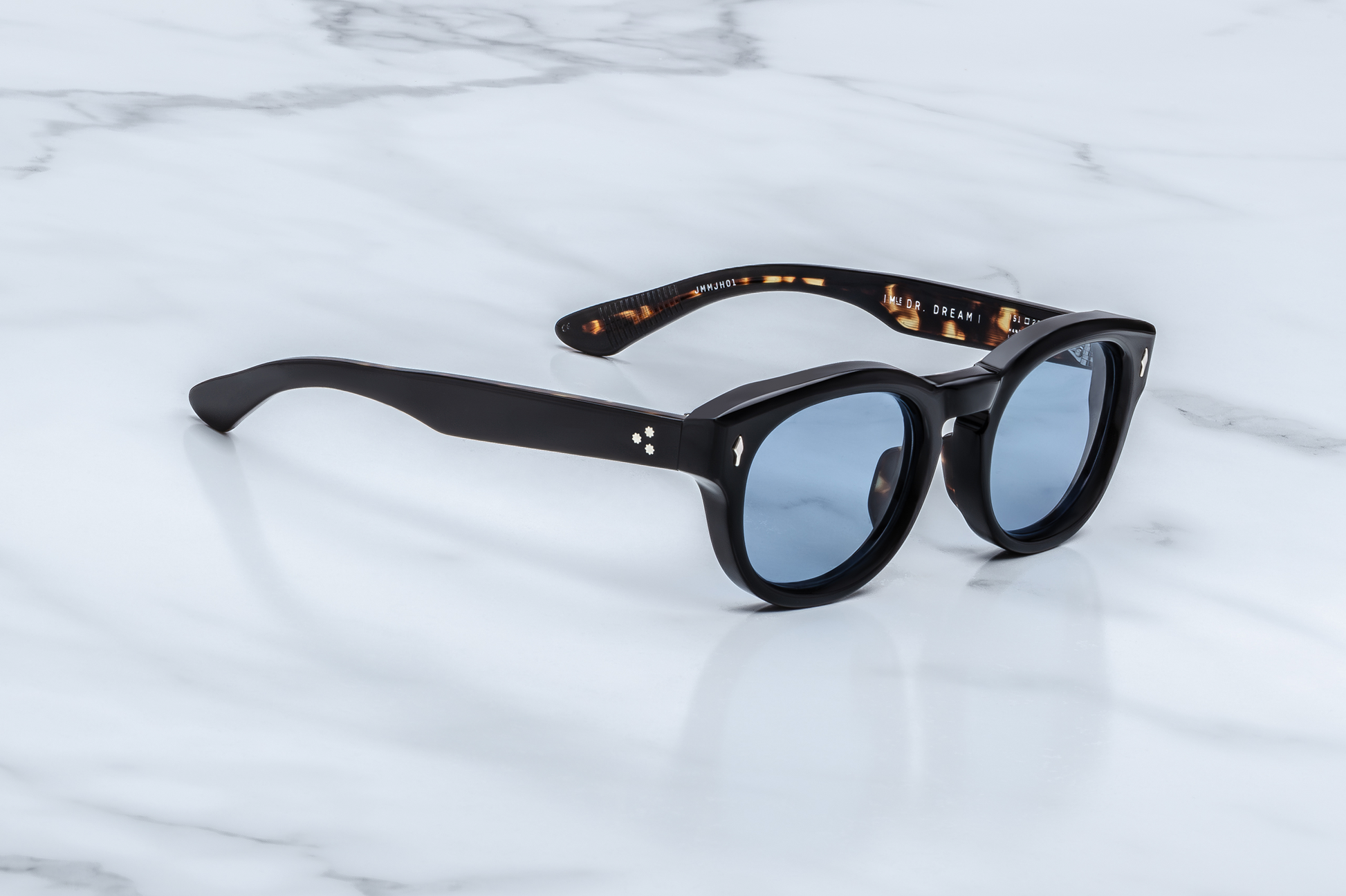 Side profile of the Dr. Dream Noir — sleek black double-laminated temples revealing semi-exposed wire-core and custom silver 7-barrel hinge, honoring the John & Yoko by JMM legacy