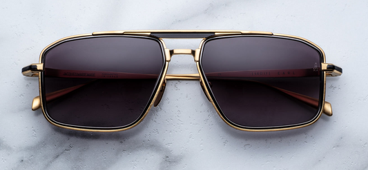 Front view of Jacques Marie Mage Earl CIA sunglasses: ‘70s-inspired titanium navigator frame in dark‑gold beta titanium with black eyerim inserts, jet-gradient CR‑39 lenses with backside AR, and Art Deco arrowhead embellishments