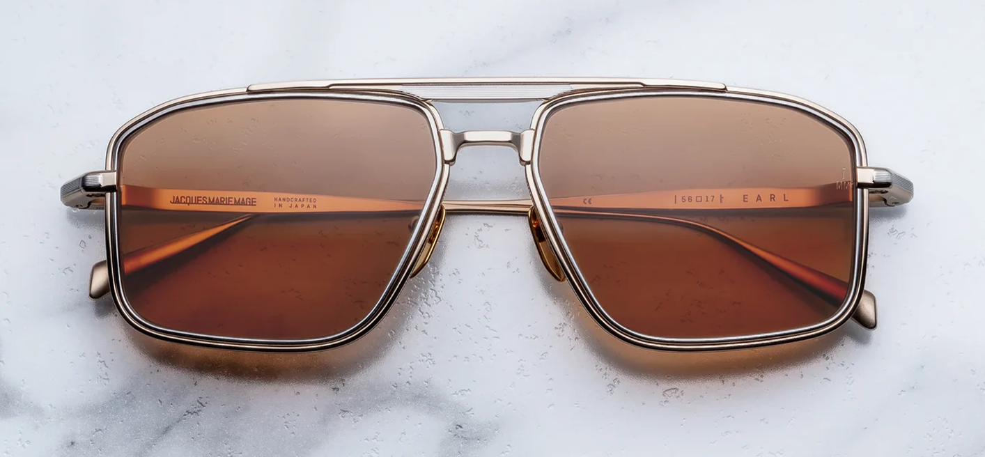 Front view of Jacques Marie Mage Earl sunglasses in Darjeeling, showcasing a sleek 1970s-inspired beta titanium navigator frame with brown lenses and a distinctive dual-tone gold and silver double bridge