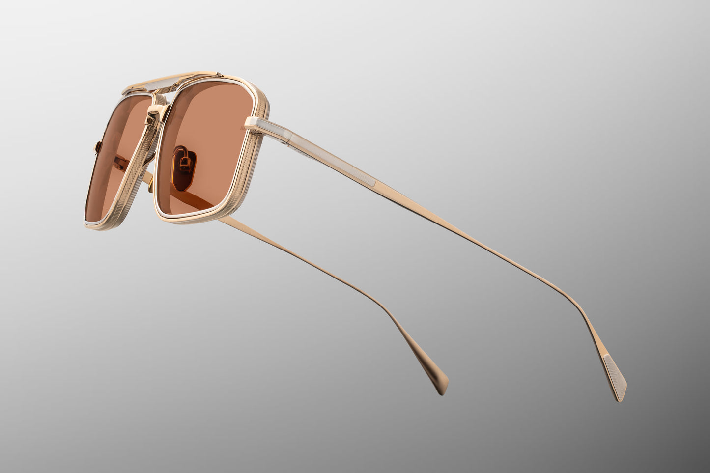 Side view of the JMM Earl sunglasses temple arm, showcasing the ultra-thin gold-finished beta titanium temple, custom hidden hinges, and the subtle silver palladium accents running along the metal wire.