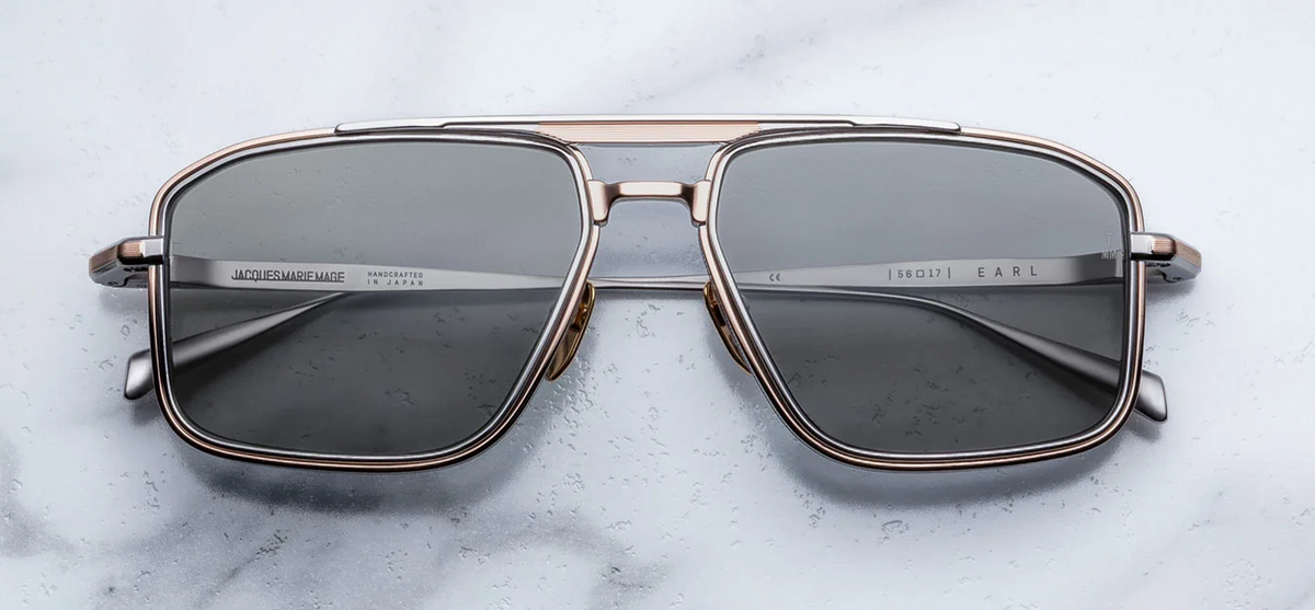 Front view of Jacques Marie Mage Earl sunglasses in Sweetheart, featuring a polished rose gold titanium navigator frame with dual-tone detailing and smoky ash grey lenses.