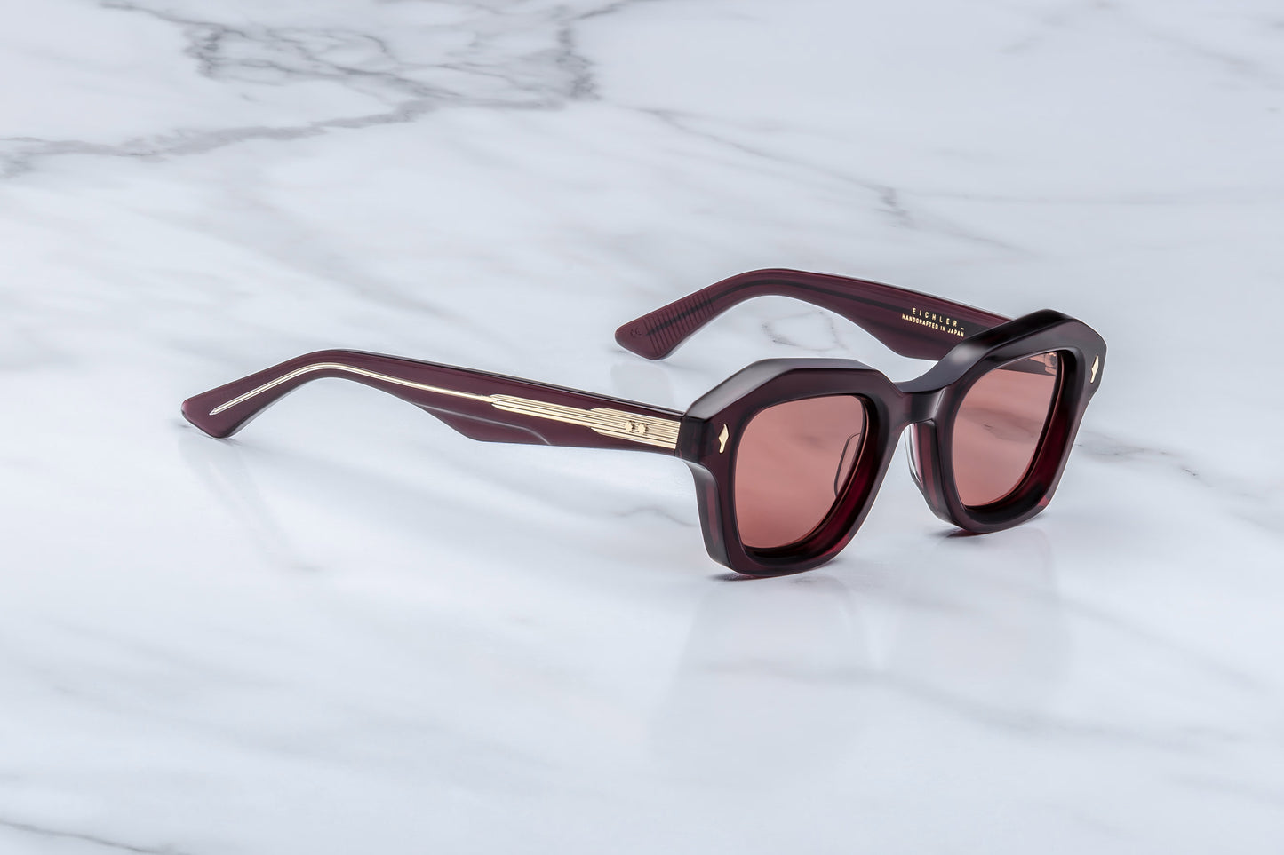 Jacques Marie Mage Eichler Amarena side view showing slim red acetate temples, exposed wirecore and custom ball hinge detail
Side profile of JMM Eichler Amarena sunglasses highlighting lightweight geometric frame and premium acetate construction