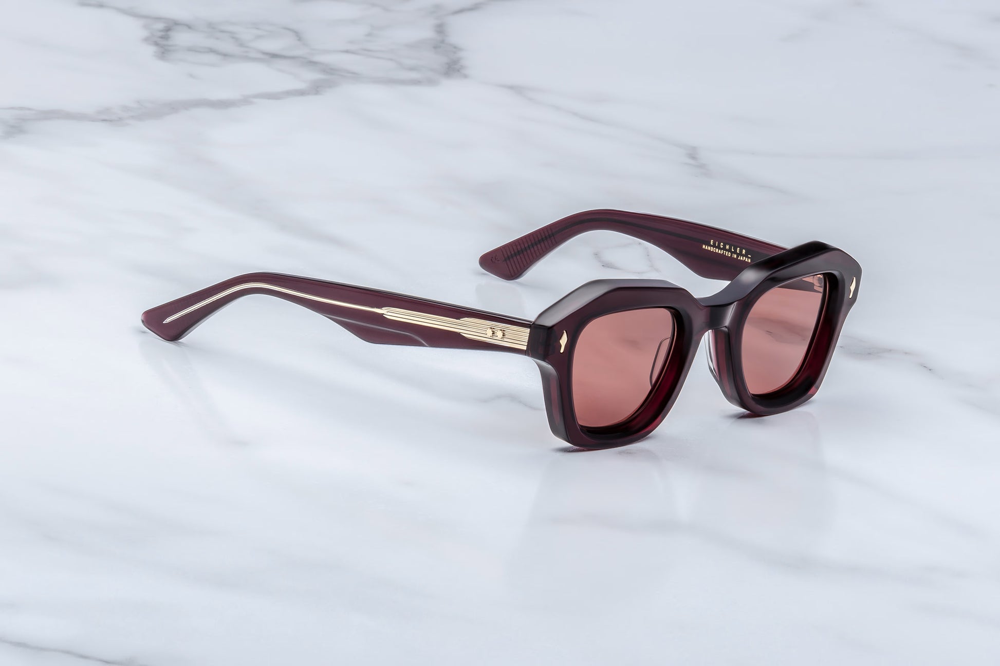 Jacques Marie Mage Eichler Amarena side view showing slim red acetate temples, exposed wirecore and custom ball hinge detail
Side profile of JMM Eichler Amarena sunglasses highlighting lightweight geometric frame and premium acetate construction