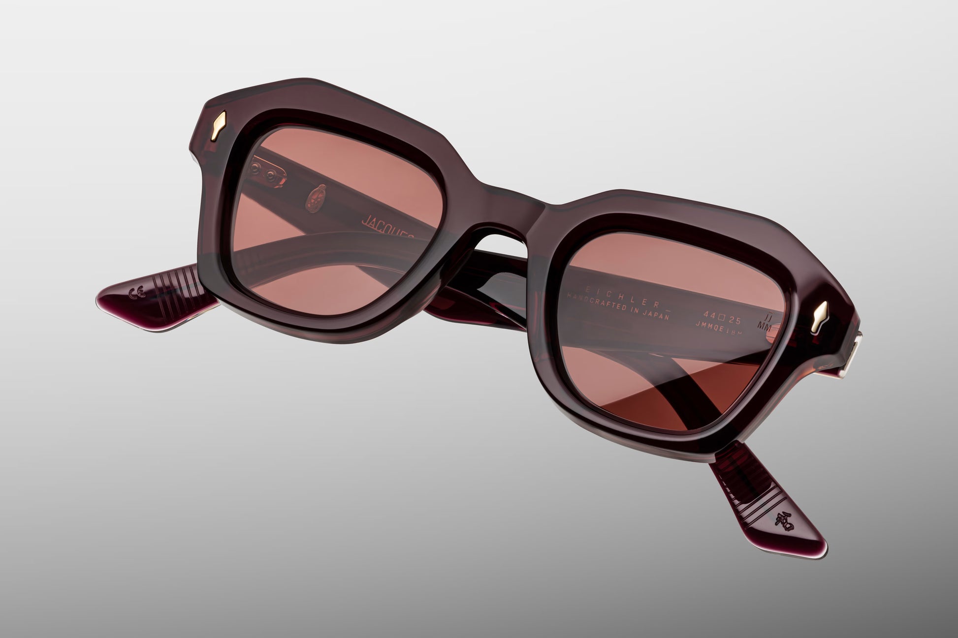 Close-up front detail of Jacques Marie Mage Eichler Amarena frame showing bevelled edges, arrowhead pins and polished red acetate finish
Macro front view of JMM Eichler Amarena sunglasses highlighting geometric lens shape and handcrafted construction
