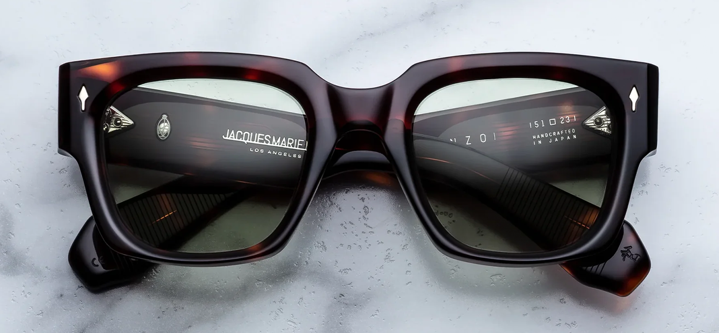Front view of Jacques Marie Mage Enzo sunglasses in Tenace Havana tortoise shell acetate, showcasing an oversized blocky 1960s-inspired frame with light green lenses and sterling silver arrowhead pins.