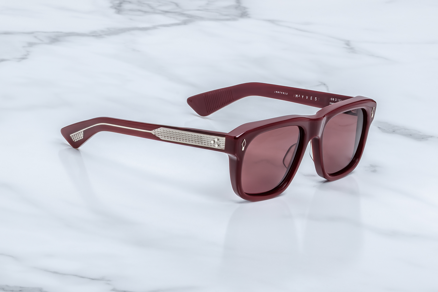 Profile of Yves Cassis — double‑laminated temples in clear-over-cassis acetate showing exposed silver ‘baguette’ wire-core and elegant hairline-engraved 7‑barrel hinge