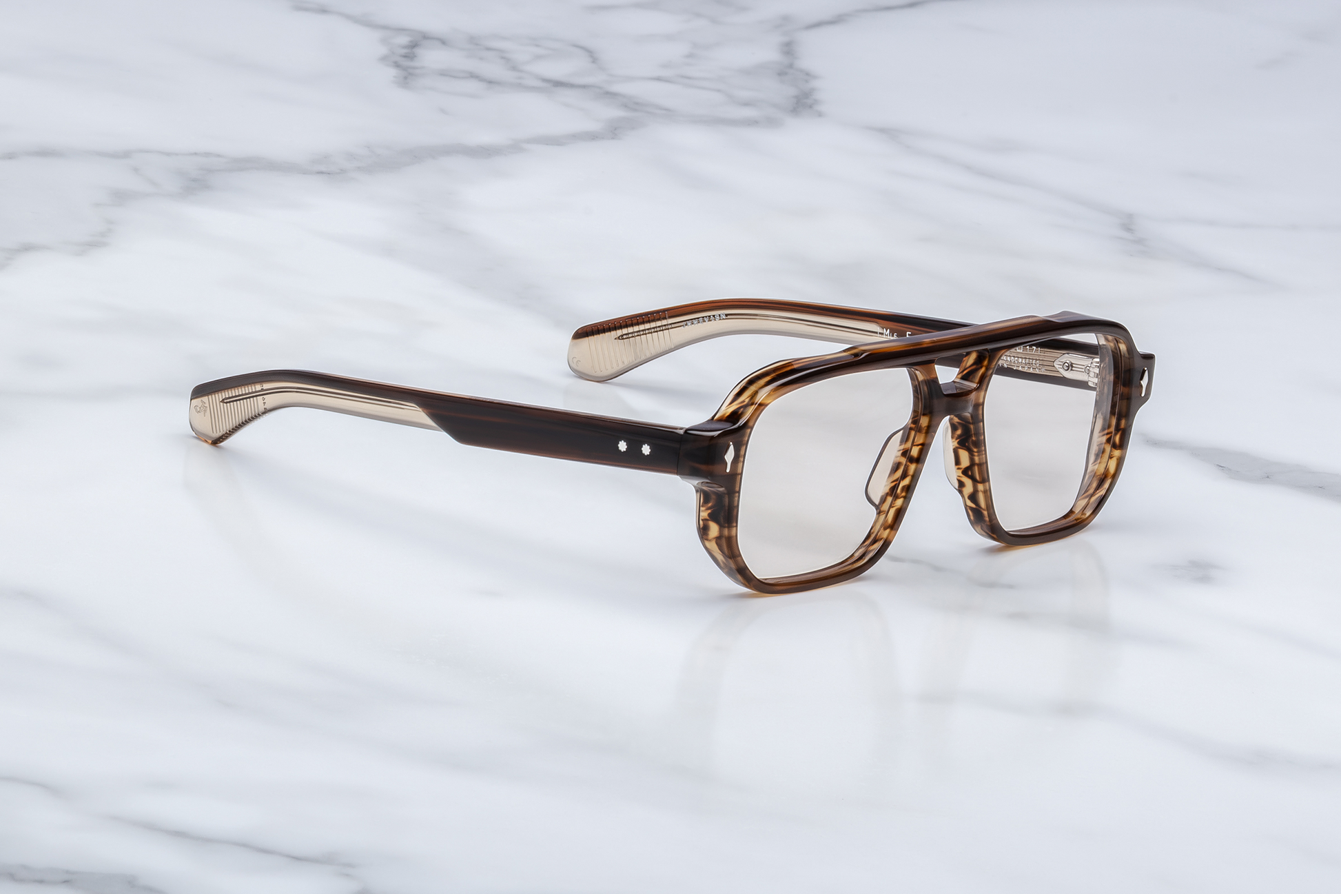 Side profile of Evans Hazel showing custom double‑laminated acetate temples, hidden wirecore, sterling silver tension‑secured 7‑barrel hinge with spur‑shaped rivets, and 3D metal cameo logo