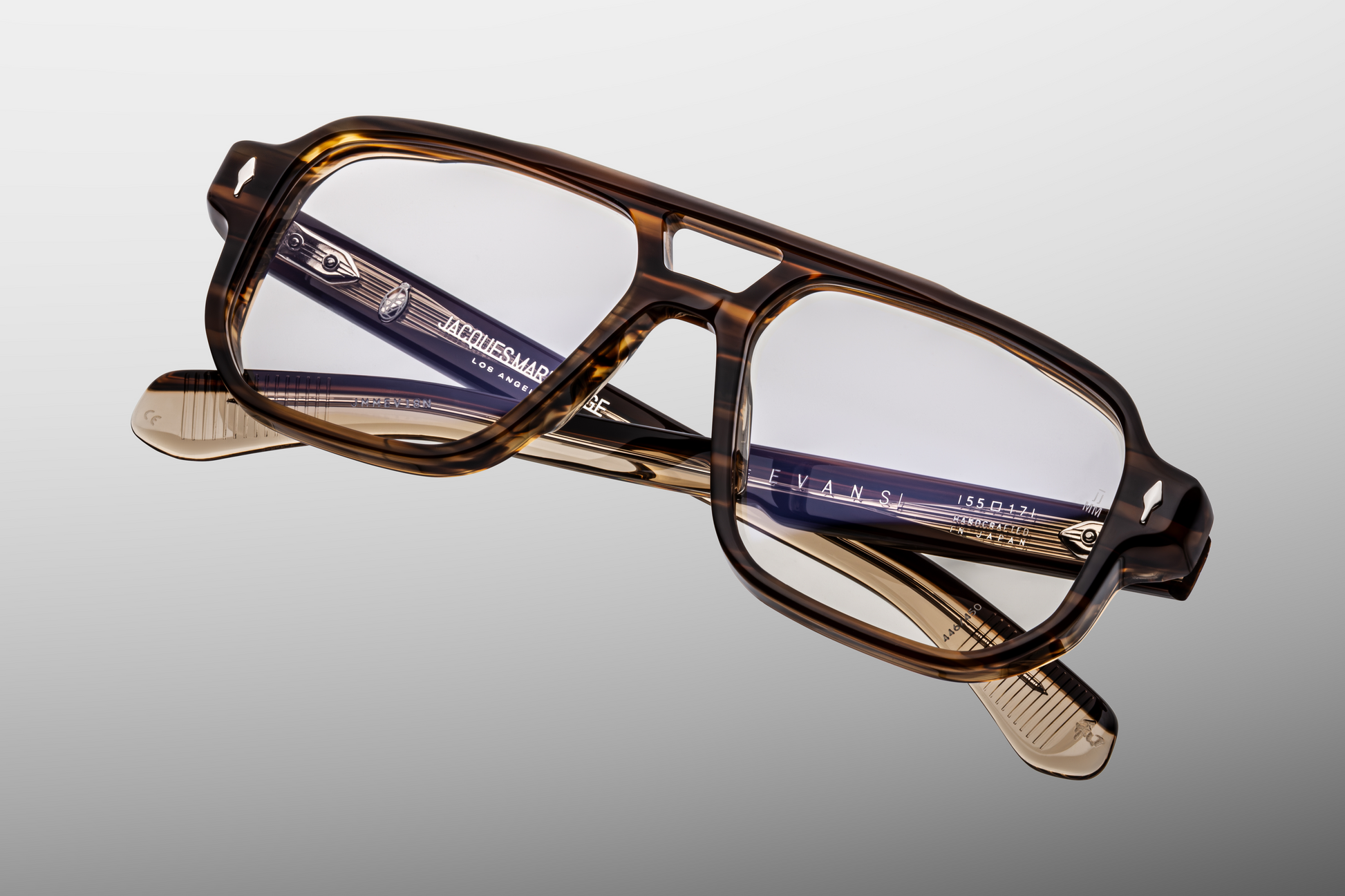 Angled view of Evans Hazel eyeglasses emphasizing superlight brown CR‑39 demo lenses with backside anti‑reflective coating, broad navigator coverage, and refined Japanese‑made acetate construction