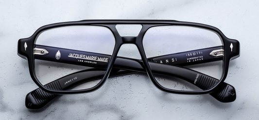 Front view of Jacques Marie Mage Evans Raven eyeglasses featuring a bold 1960s‑inspired oversized navigator silhouette in 8 mm black cured acetate, with distinct double‑nose‑bridge, exposed wirecore, and black arrowhead front pins