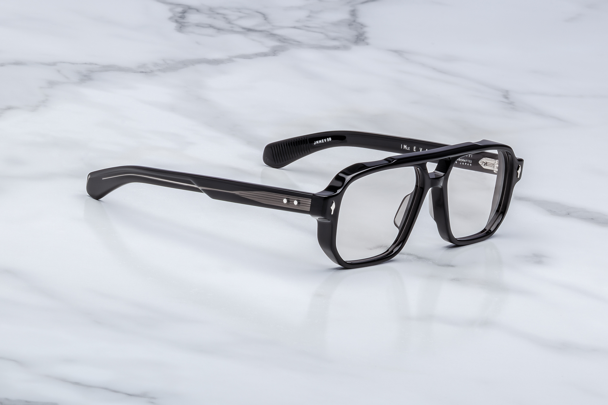 Side profile of Evans Raven showing custom double‑laminated acetate temples with exposed silver wirecore, tension‑secured 7‑barrel hinge adorned by spur‑shaped rivets, and a 3D metal cameo logo