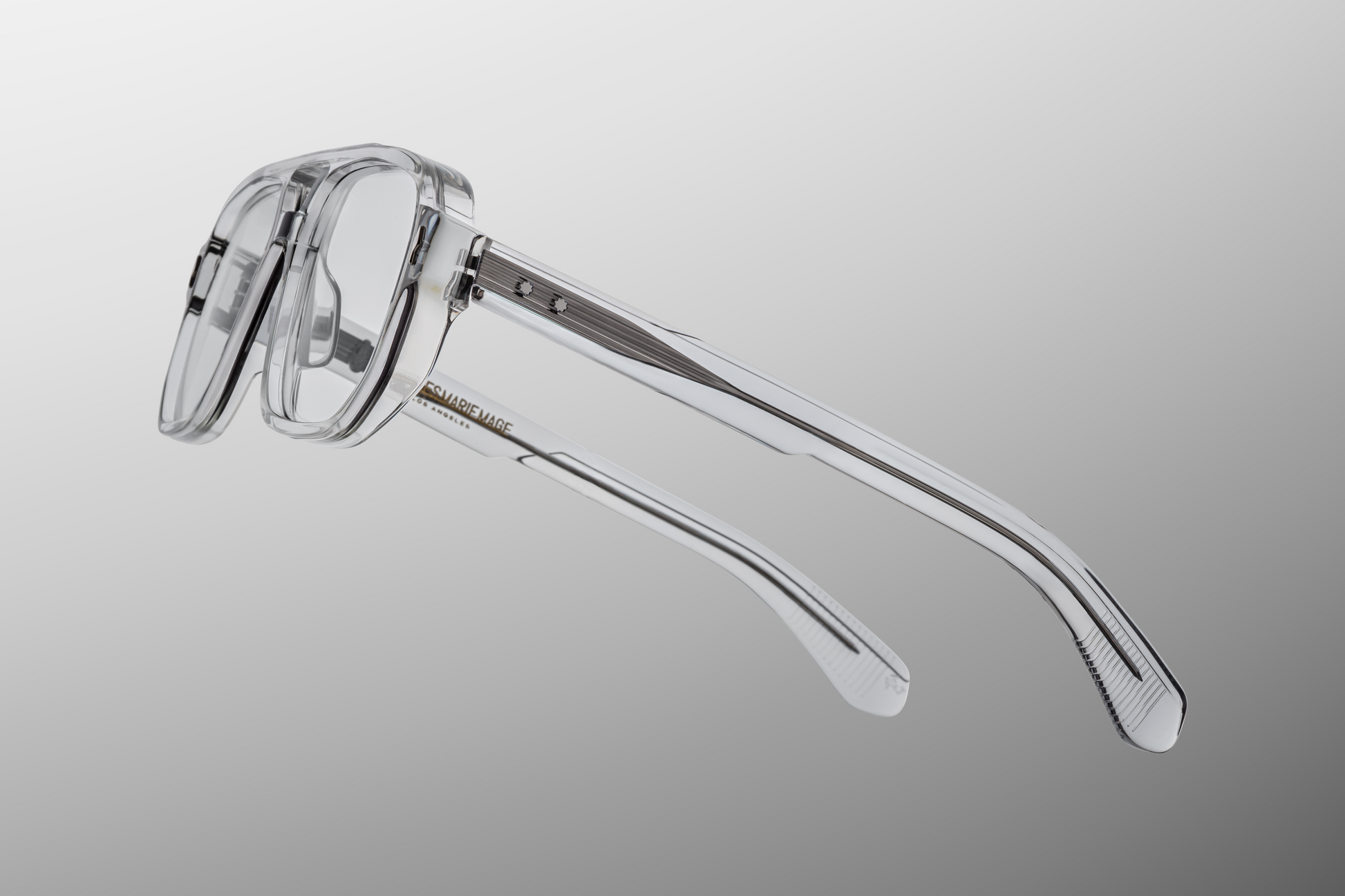 Side profile of Evans Sulfur highlighting custom double‑laminated sulfur acetate temples, exposed sterling silver filigree-engraved wirecore, sterling silver tension‑secured 7‑barrel hinge with spur-shaped rivets, and domed 3D metal cameo logo