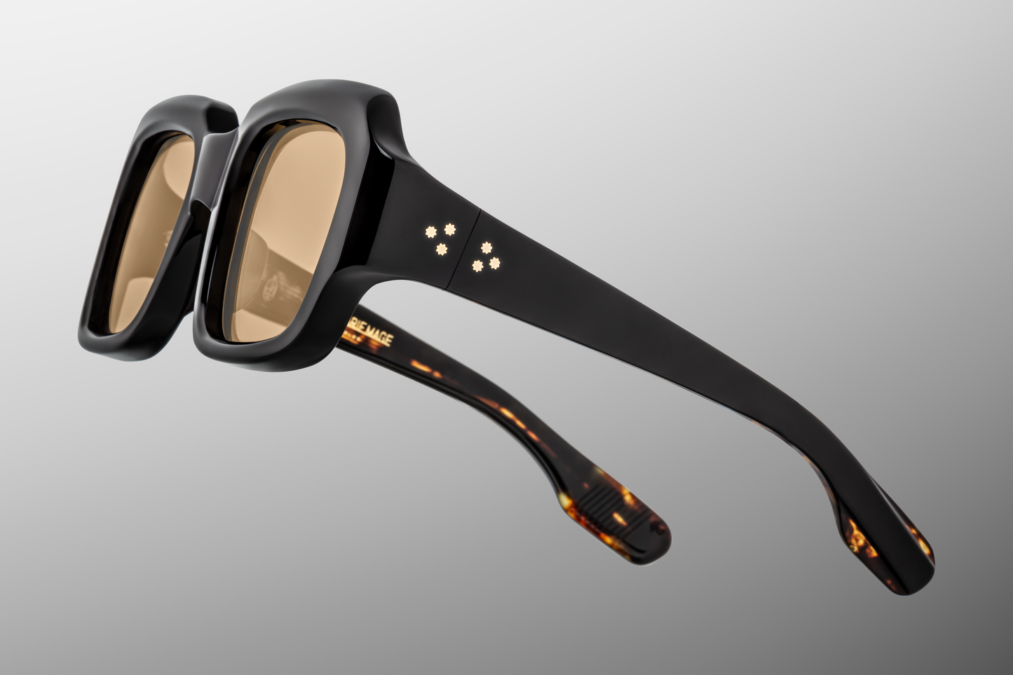 Side/temple view of ‘Monday Monday’ sunglasses: thick black acetate temples, subtle 18k gold detailing near hinge, tapering curves toward earpiece