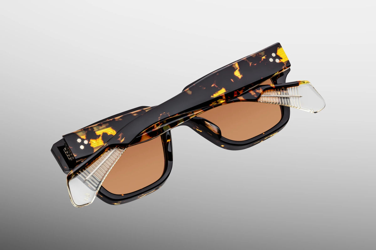 Detailed close-up view from behind the hinge of the JMM Fellini Tokyo sunglasses. The perspective reveals a heavy-duty, silver-plated custom 9-barrel tension-secured hinge featuring refined hairline detailing and silver spur-shaped rivets. Silver foil-stamped inner hallmarks and branding are cleanly stamped across the smooth interior temple arm