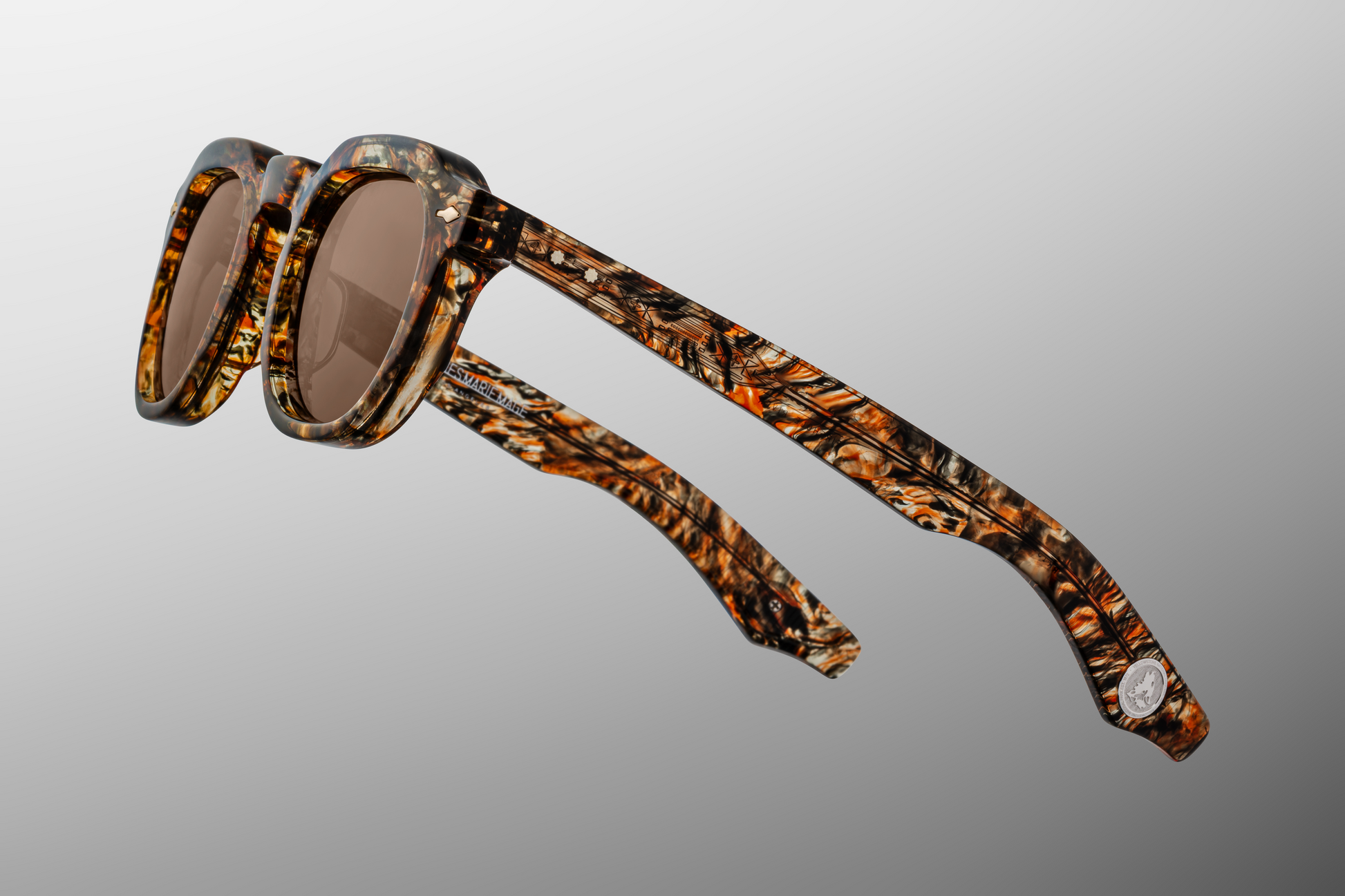 Side profile of Firehole River glasses showcasing custom 5-barrel hinges, hairline-engraved 'Spiketail' wirecores in Light Gold, and silver inner-temple markings. Yellowstone VI
