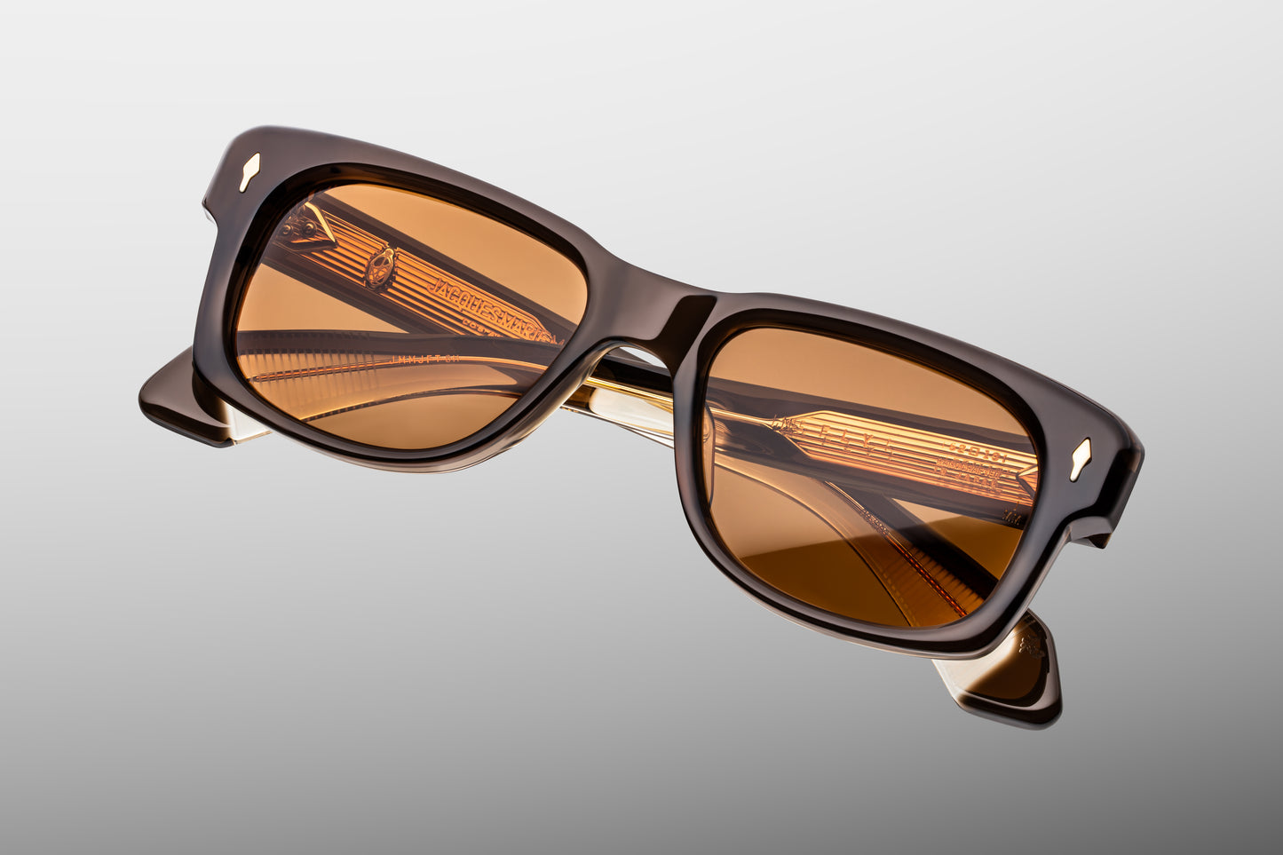 Close-up front detail of Jacques Marie Mage Fly London frame showing bevelled brow, arrowhead rivets and polished acetate finish
Macro front view of JMM Fly London sunglasses highlighting rounded rectangular lens shape and handcrafted construction