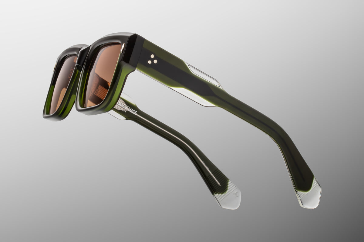 Detailed close-up of the temple arm on Jacques Marie Mage Hemmings Borneo sunglasses. The clear laminated inner acetate exposes a polished gold wire core meticulously engraved with Art Deco filigree linework. WINK OPTOMETRISTS