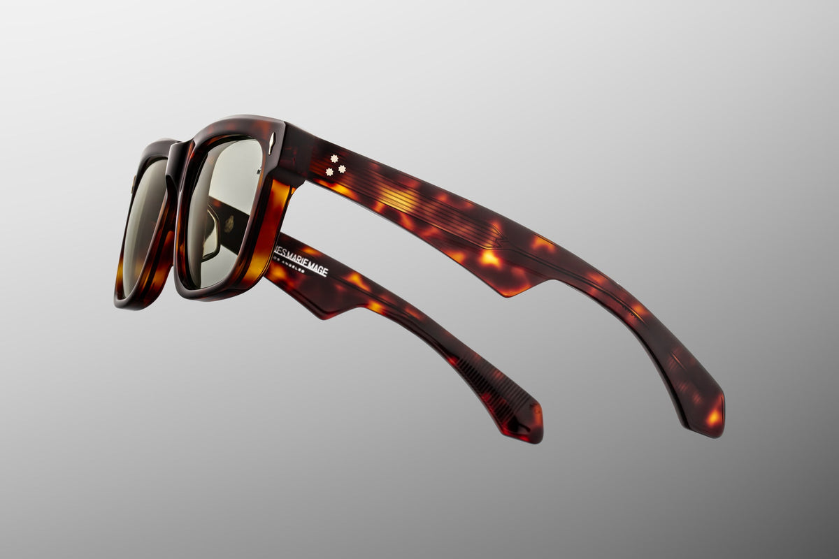 Side profile of Jacques Marie Mage Hyannis Tenace sunglasses, highlighting the tortoiseshell temples, custom silver palladium hinges, and light bottle green lenses
