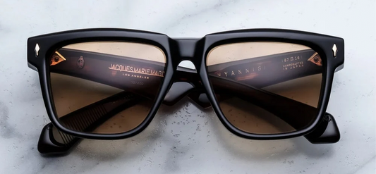 Front view of Jacques Marie Mage Hyannis sunglasses in Noir 15, showing the bold black rectangular acetate frame and signature 18k gold arrowhead pins.