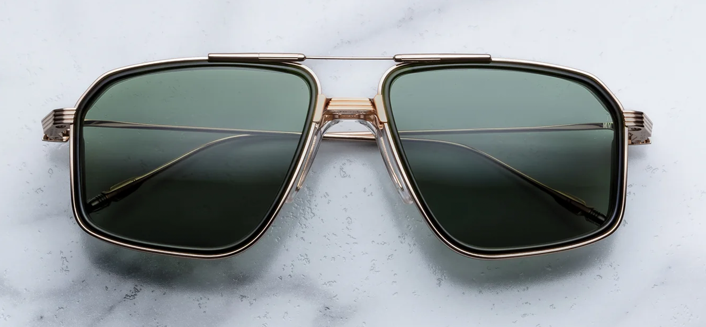 Front view of Jacques Marie Mage Jagger sunglasses in Cypress, featuring oversized 1970s-style titanium aviator frames in polished light gold with green acetate inner rim inserts and Moss green lenses