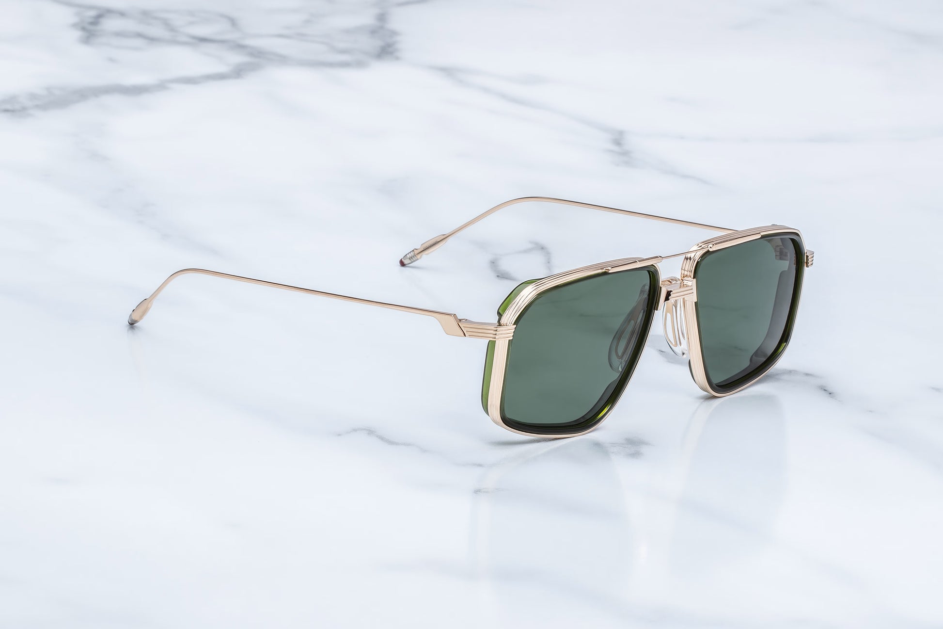 Side view of the JMM Jagger Cypress sunglasses temple arm, showcasing the ultra-slim, polished light gold beta titanium temples and the seamless transition into the monoblock hinges