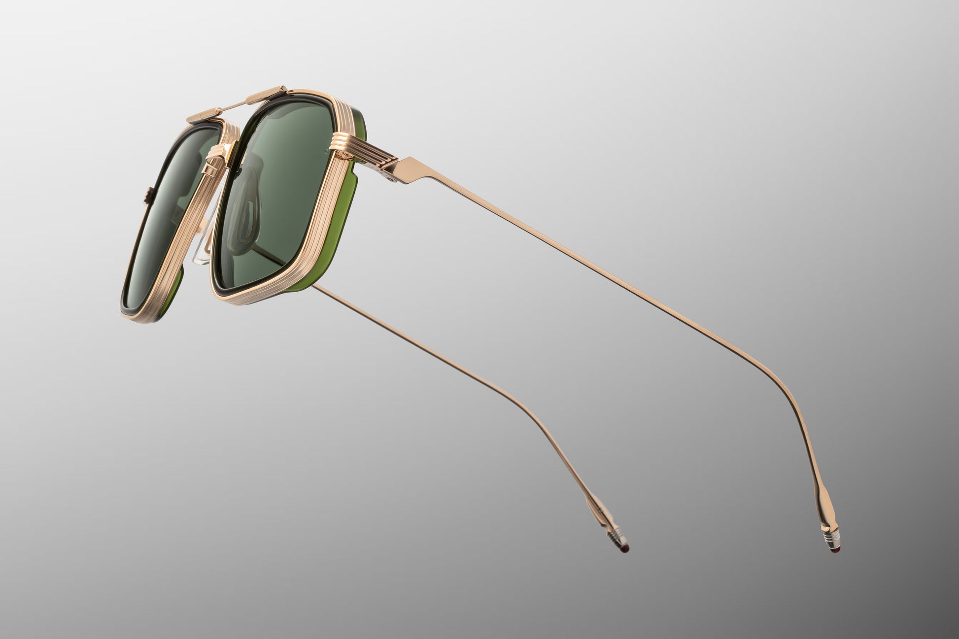 Side view of the JMM Jagger Cypress sunglasses temple arm, showcasing the ultra-slim, polished light gold beta titanium temples and the seamless transition into the monoblock hinges