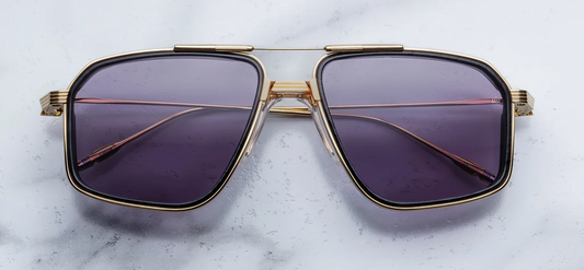 Front view of Jacques Marie Mage Jagger sunglasses in Ebony, showing oversized 1970s-style titanium aviator frames in Moon Gold with black burlwood acetate inner rim inserts and Nimbus gray lenses