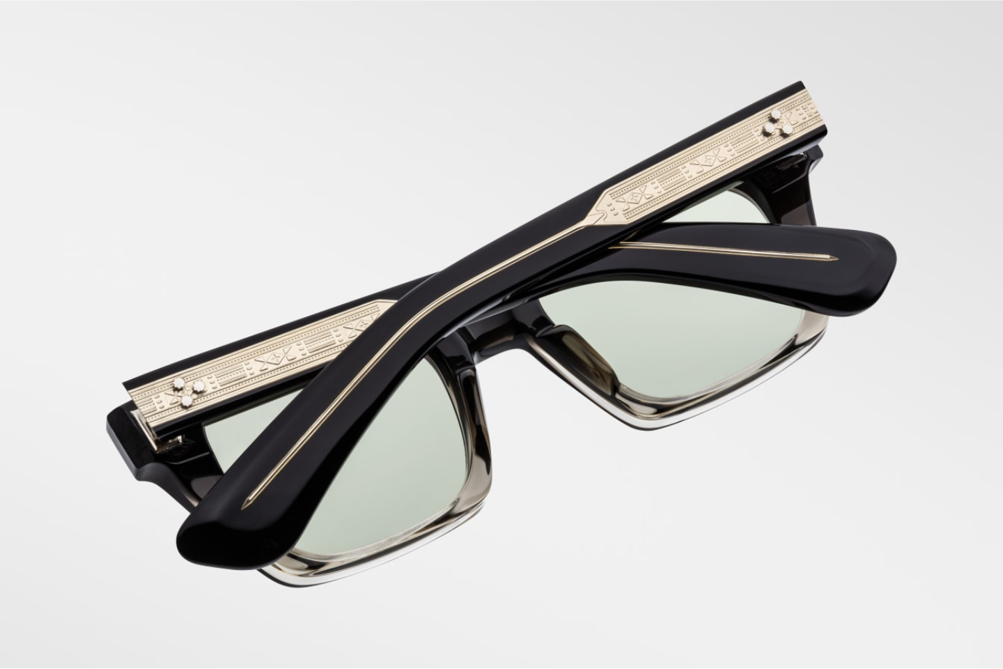 Jacques Marie Mage Quentin Black Fade sunglasses from the Johnny Cash collection. The side view reveals an exposed, engraved silver spike tail wire-core set into the temple’s lamination, secured with a tension secured 9-barrel hinge and sterling silver hatchet-shaped front pin. The lenses are lightly tinted green Serpent Amorlite CR39 with full UV protection. 