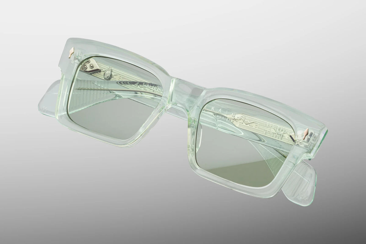 Top-down view of the Jacques Marie Mage Kaine Aurora photochromic sunglasses, emphasizing the substantial 10mm thickness of the front block acetate profile. From above, the clear light green alignment of the temples is fully visible, showcasing the internal silver wire cores and the robust multi-barrel hinges. Available at WINK Optometrists.
