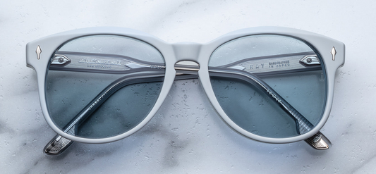 Front of JMM Kay in Sky Suede — softly rounded rectangular frame in matte pastel-blue plant-based acetate, with silver arrowhead front pins and pale blue lenses
