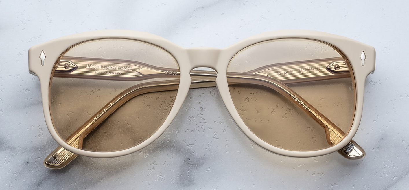 Front of the Kay Sun Suede sunglasses — a soft, round-panto frame in matte buttery yellow (suede acetate) with light golden-yellow lenses and signature arrowhead silver front pins