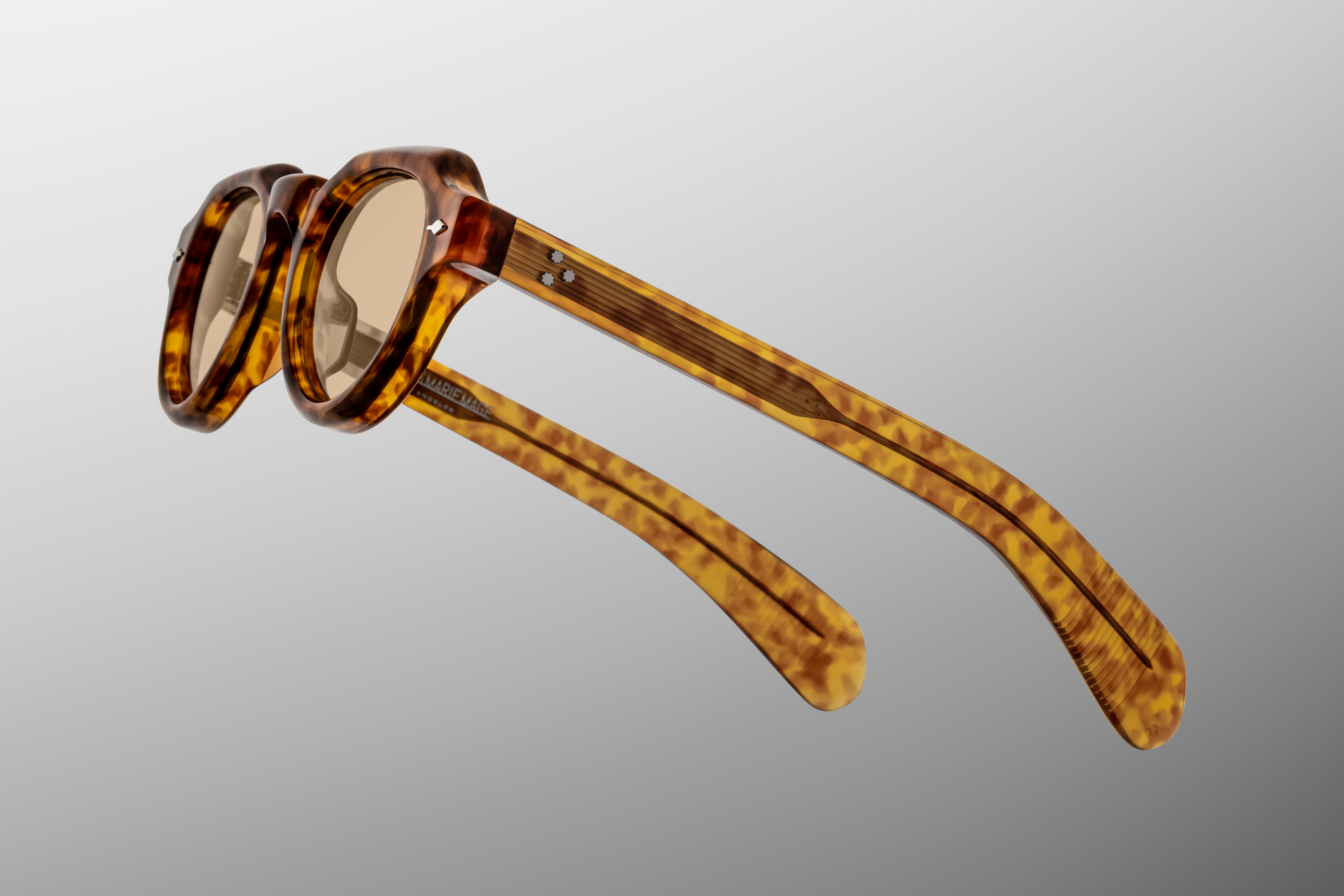 Close up detail of Kellerman Camel: section where lens meets frame, showing bevels and polish of the acetate, the arrowhead pin detail, and the texture/pattern of the camel tone under light
