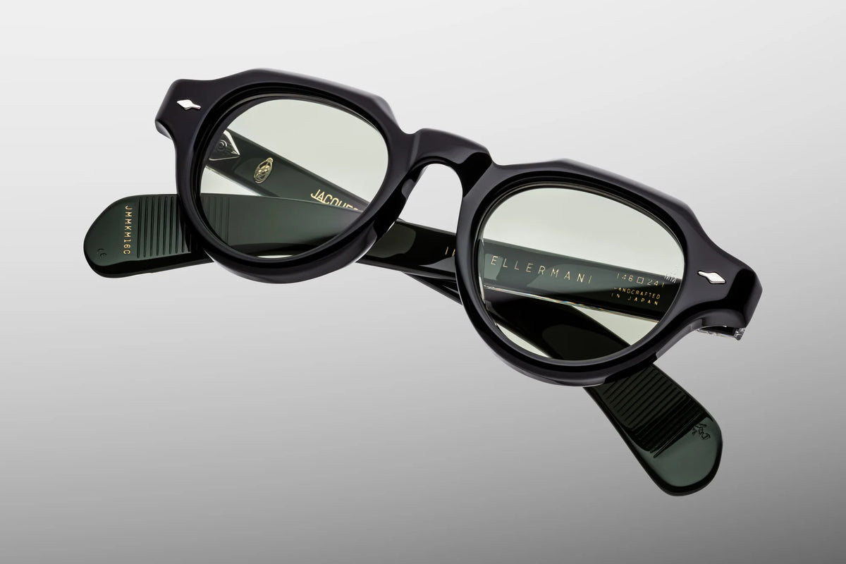Top-down view of the Jacques Marie Mage Kellerman Cobra eyeglasses, emphasizing the dramatic 10mm thickness of the front block acetate profile. From above, the unique dual-tone black and green double-laminated construction of the paddle temples is fully exposed, showcasing the parallel alignment of the custom silver wire cores and the heavy-duty 7-barrel hinges. Available at WINK Optometrists.